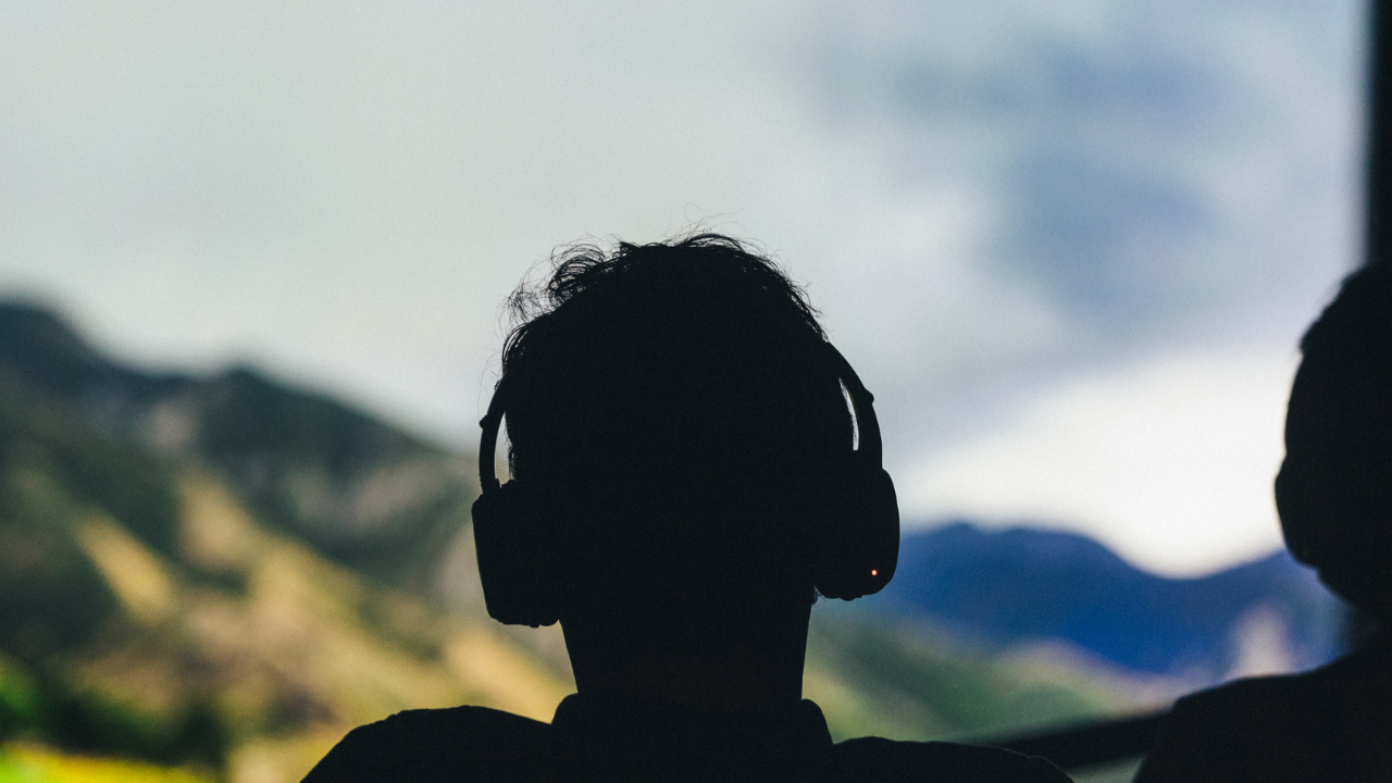 An audience member wearing headphones at a performance of 32 SOUNDS